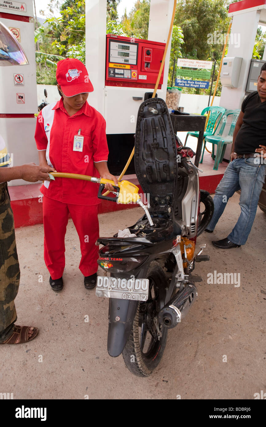 Indonesia Sulawesi Tana Toraja Makale female Pertamina petrol station attendant filling motorcycle Stock Photo