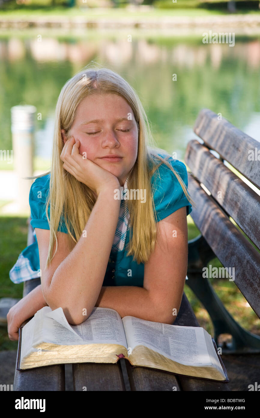 Child praying 10 12 year olds 11 years old Caucasian Junior high girl reading Bible meditating reflecting young person people Tween tweens  MR © Myrleen Pearson Stock Photo