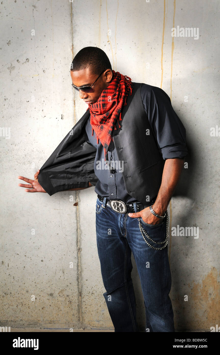 African American hip hop man pulling vest over a grunge background Stock Photo