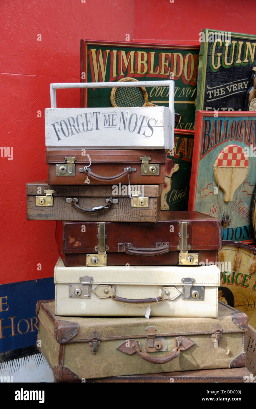 Stack of old suitcases and wooden advertising signs outside London antiques shop Stock Photo