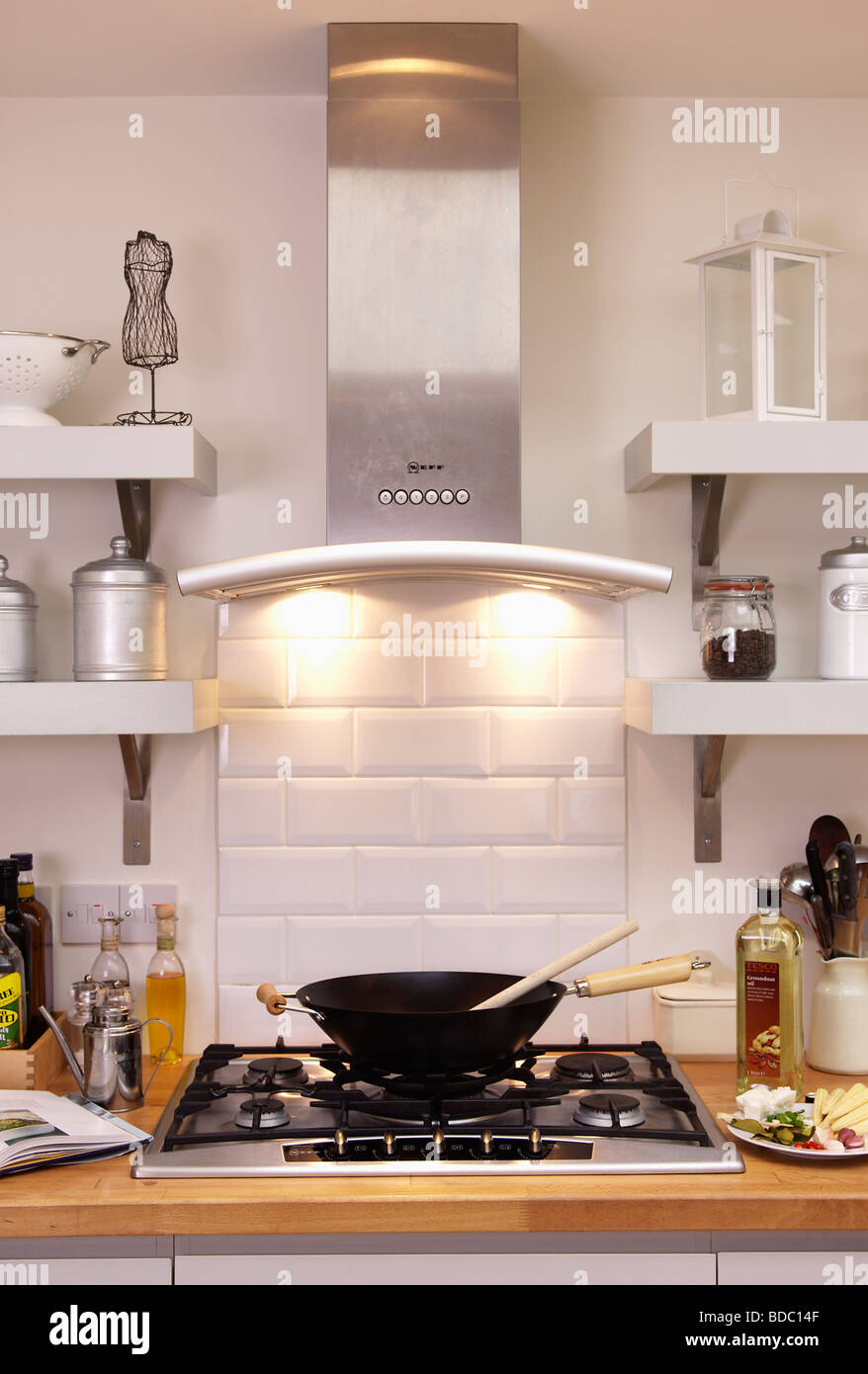 Close up of stainless steel extractor with down-lighting above wok on  stainless steel gas hob Stock Photo - Alamy