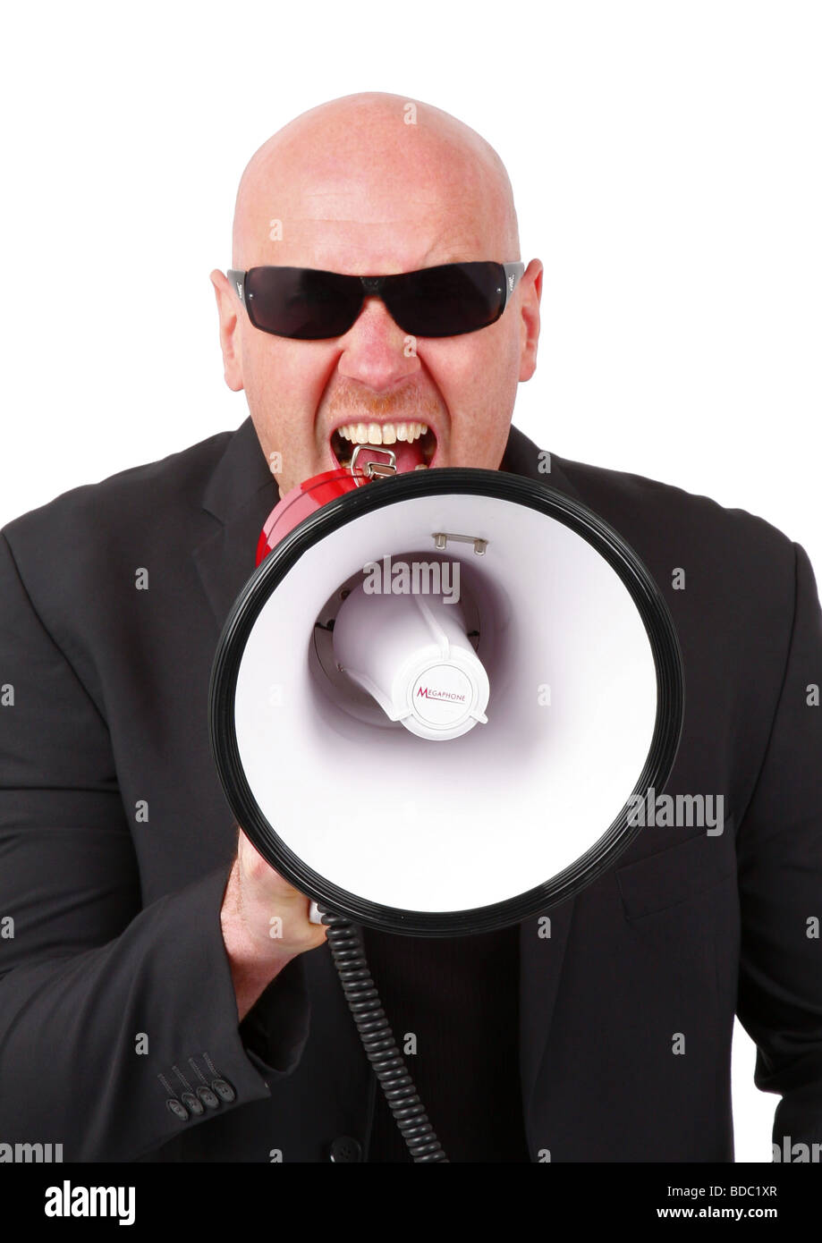 bald headed man shouting into a megaphone Stock Photo