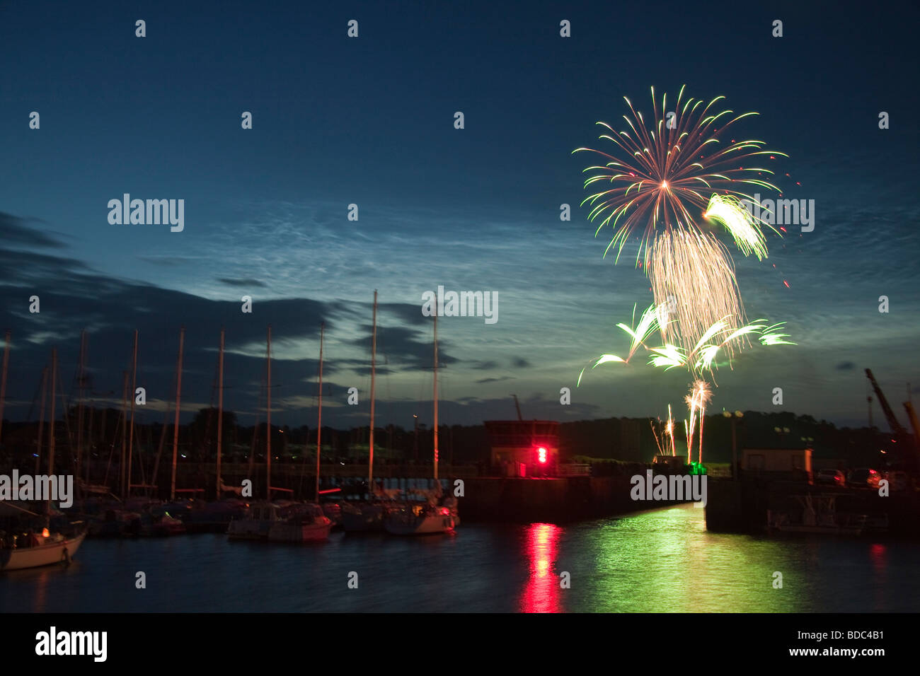 Fireworks on Bastille Day, 14th July, over the harbour and sea lock at Paimpol, Brittany, Northern France. Stock Photo