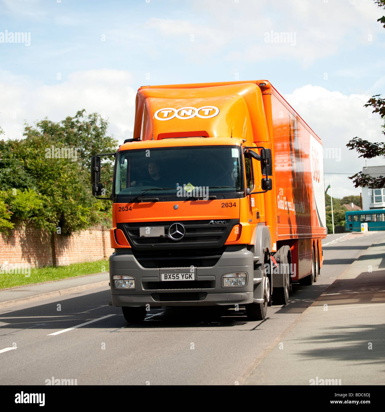 Orange coloured TNT global logistics truck HGV delivery lorry UK Stock Photo