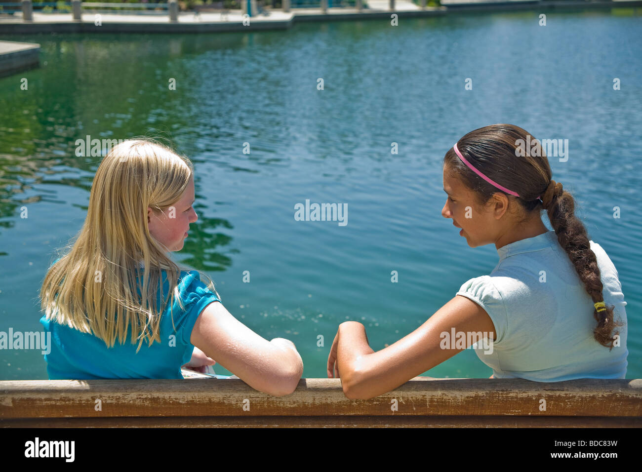 Two Tween tweens girls hang hanging out together Hispanic ethnic diverse  multi Tween tweens girls sit park bench converse young person people  ©Myrleen Pearson Stock Photo - Alamy