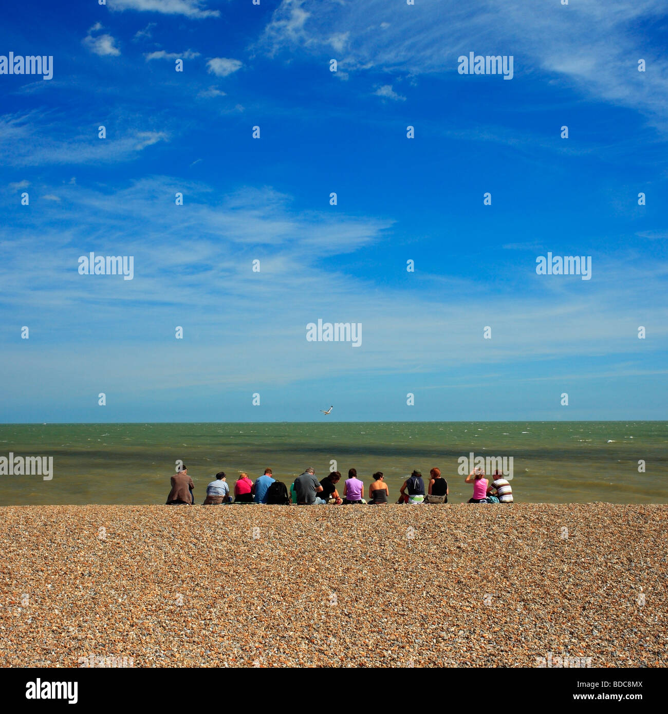 Group of people sitting on a beach. Stock Photo
