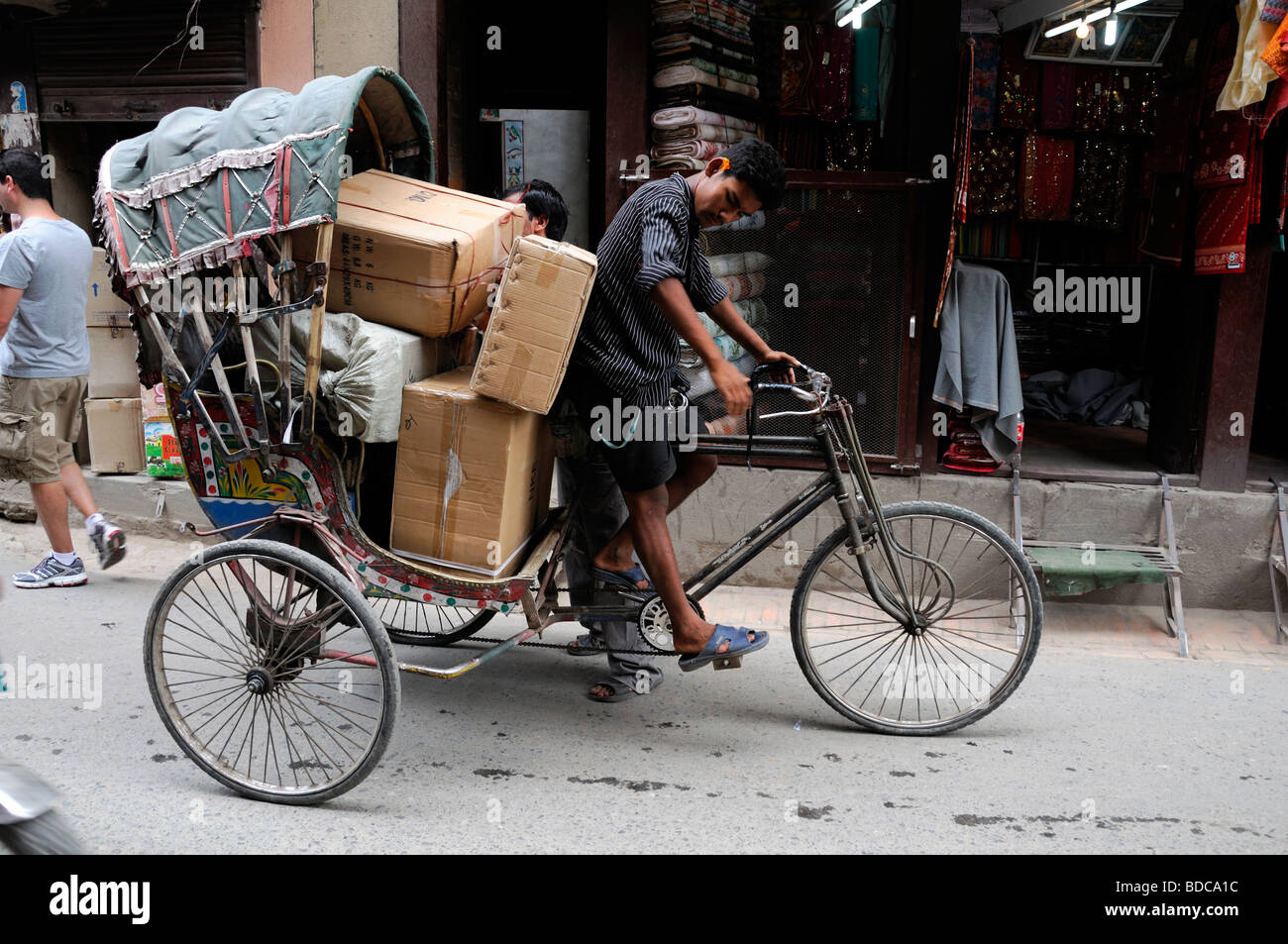 overloaded rickshaw bicycle transport heavy load struggle struggling driver cyclist  durbar square kathmandu nepal manual labor Stock Photo