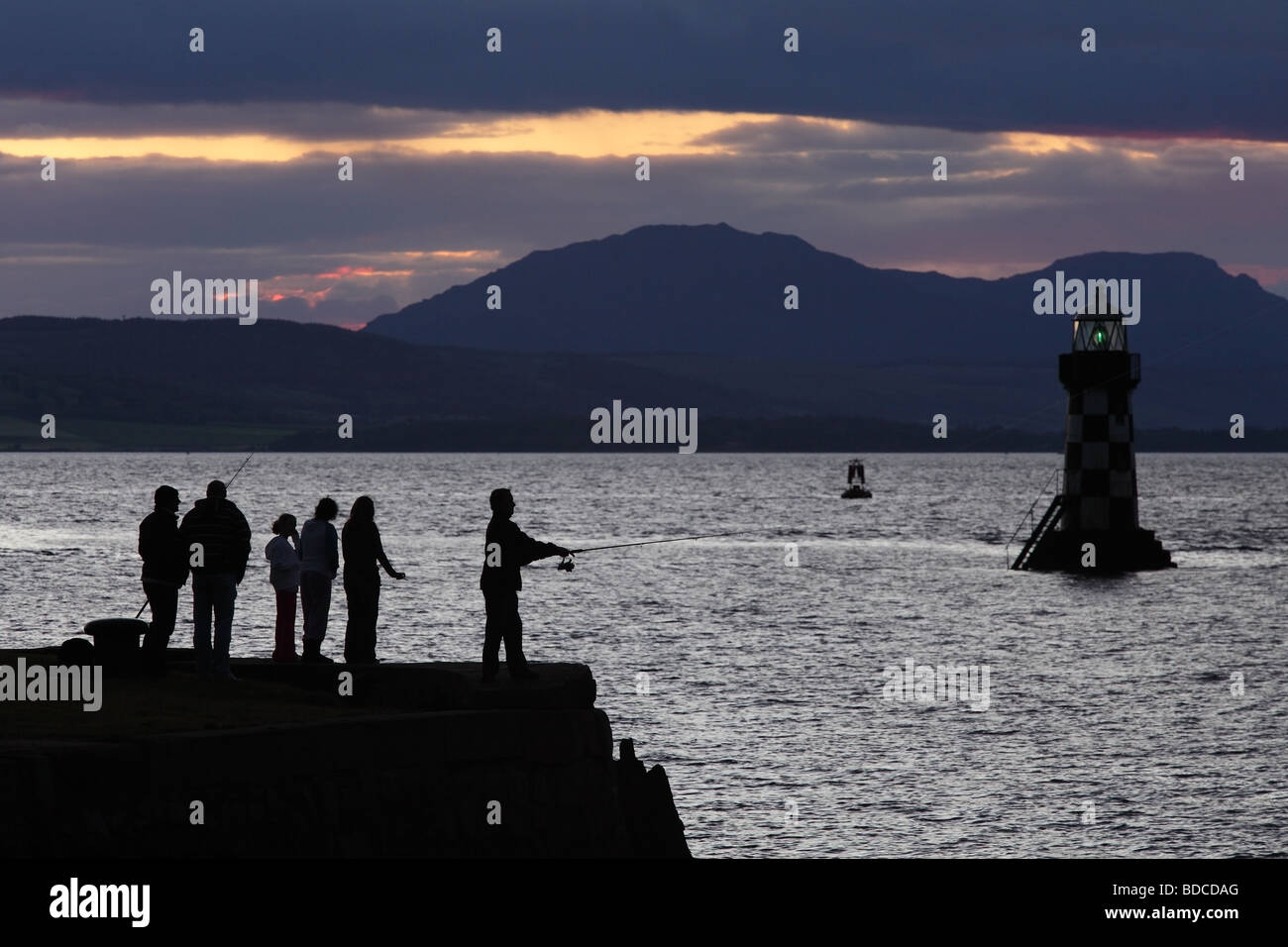 Group of people fishing at sunset on the Firth of Clyde, Port Glasgow, Scotland, UK Stock Photo