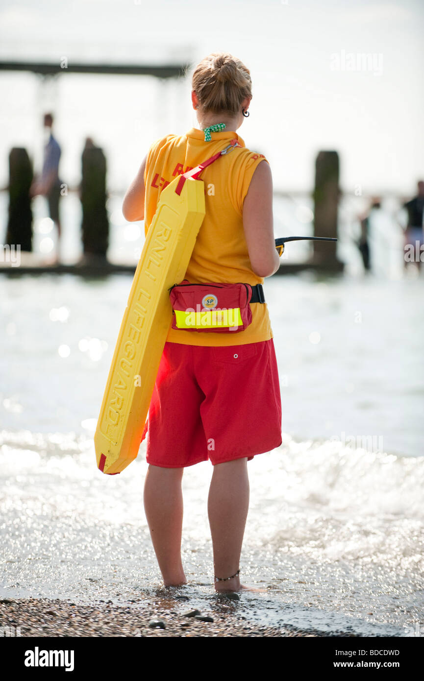 young woman RNLI lifeguard on duty patrolling Aberystwyth beach summer