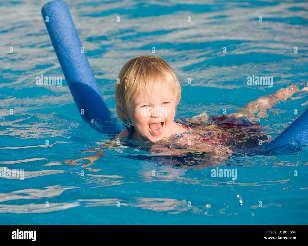 Baby girl learning to swim with aid of a noodle float Stock Photo Alamy