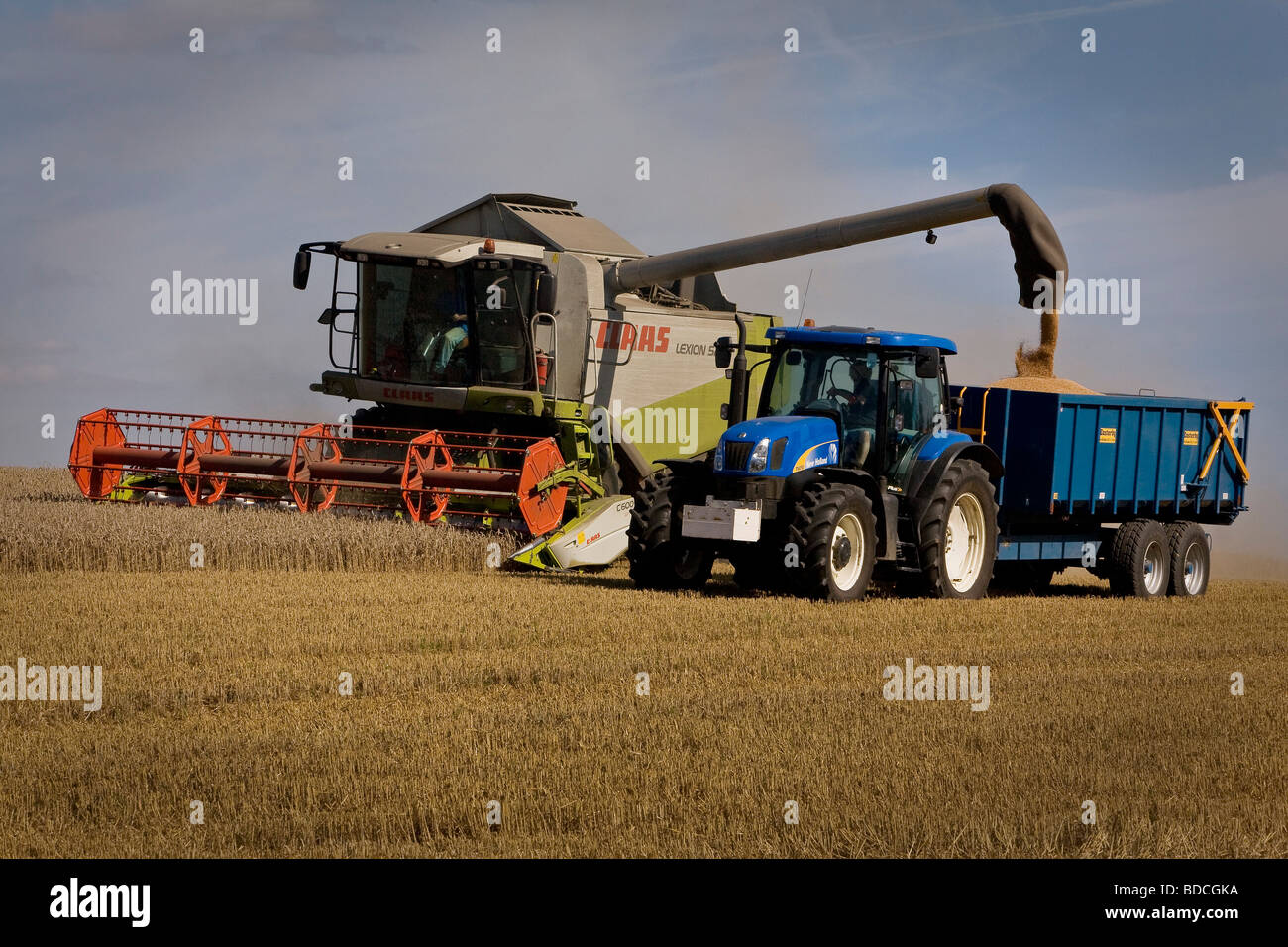 Combine Harvester and tractor at work in Ashen Essex near Clare in