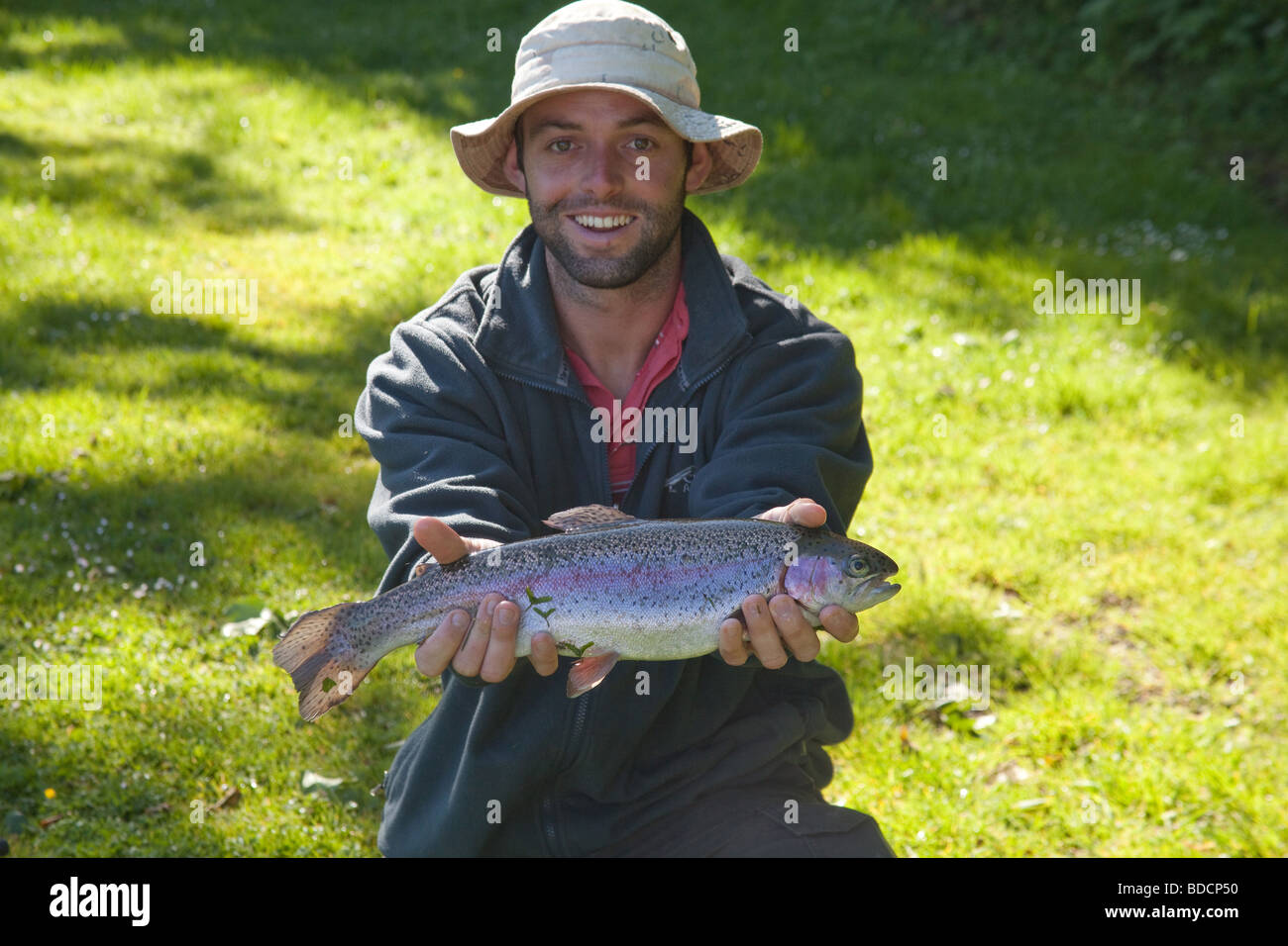 Trout fisherman with a rainbow trout at Meon Springs Trout Fishery