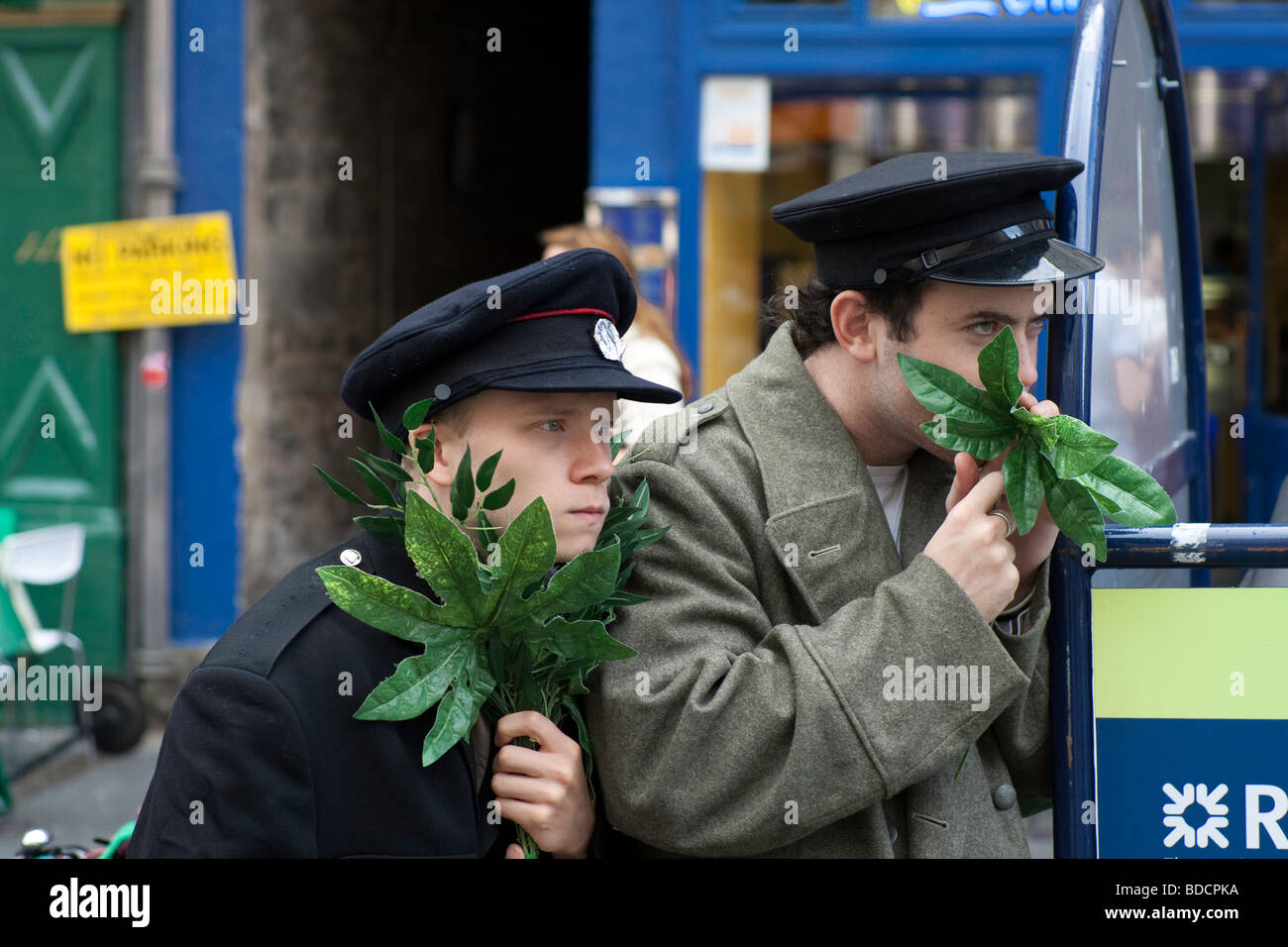 Two street performers camouflage themselves using some leaves on Edinburgh's Royal Mile as part of the Fringe festival 2009 Stock Photo