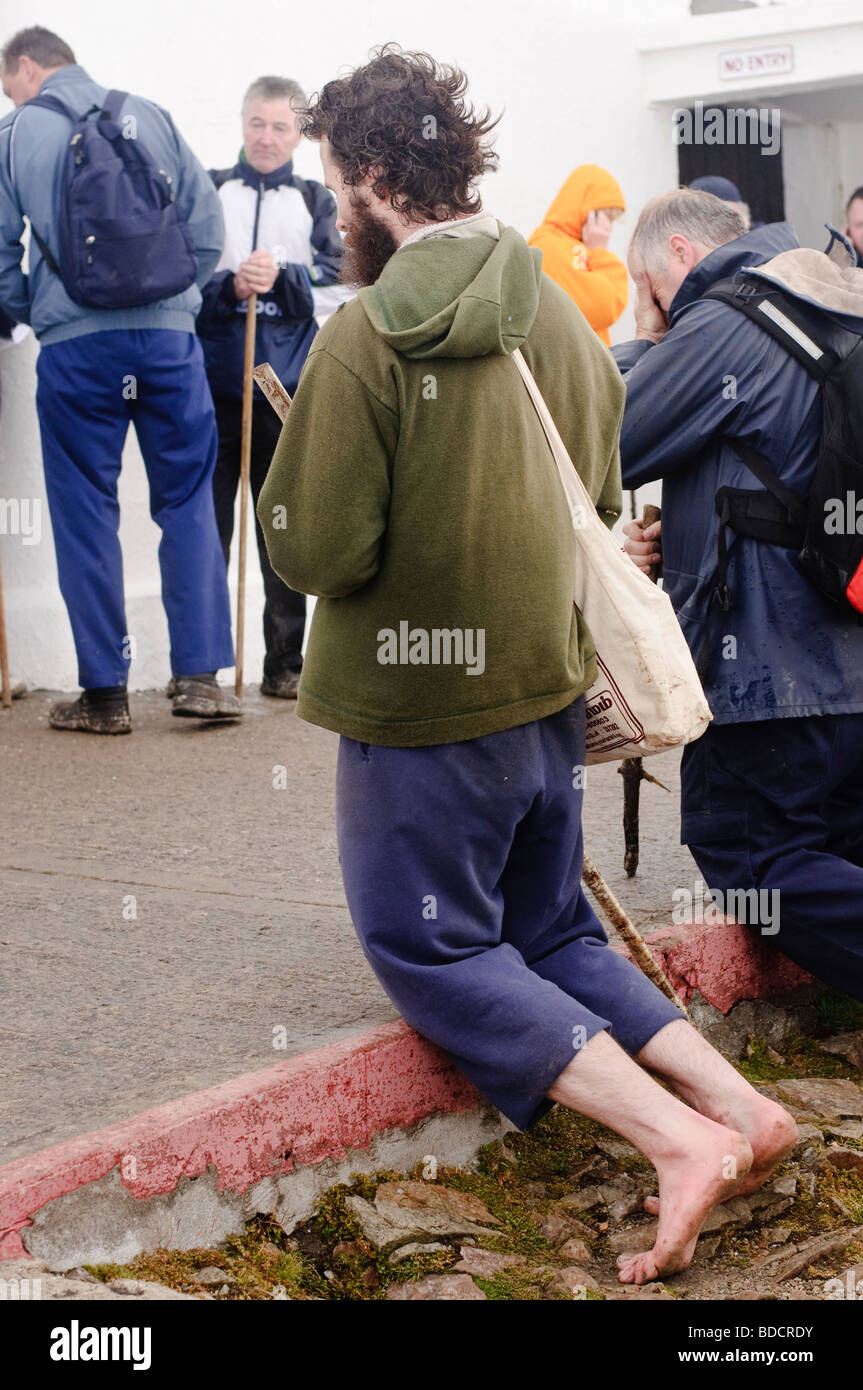 Barefoot pilgrim praying at St. Patrick's Church at the summit of