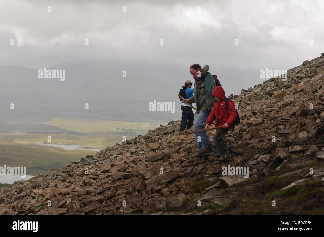 Pilgrims with walking sticks descending from the rocky top section of Croagh Patrick on Reek Sunday, 25th July 2009 Stock Photo