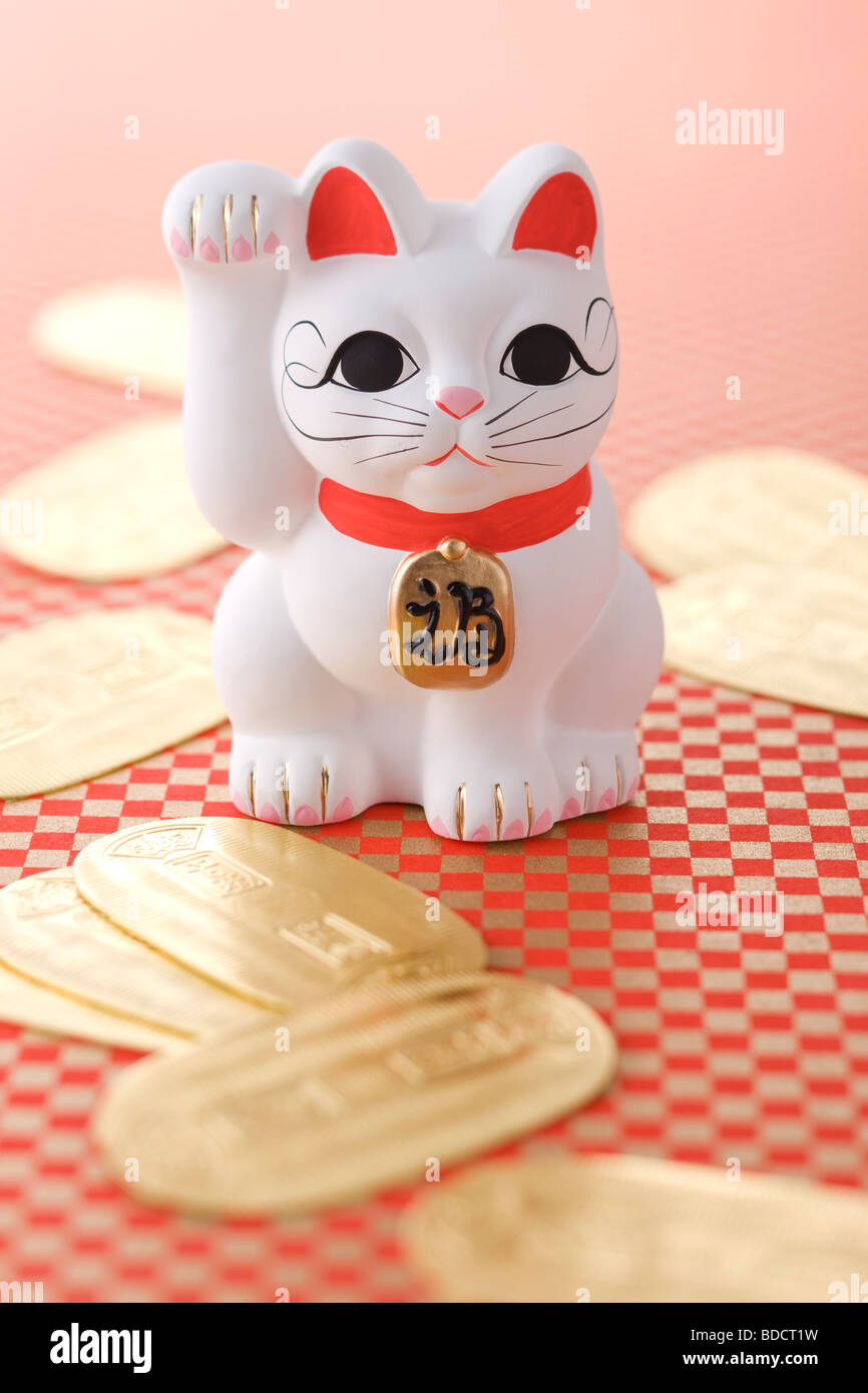 Welcoming cat and gold coin Stock Photo