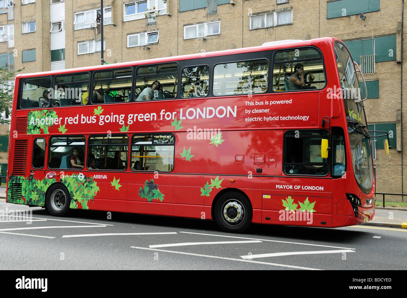 London bus powered by electric hybrid technology with Another red bus going green for London printed on the side England UK Stock Photo