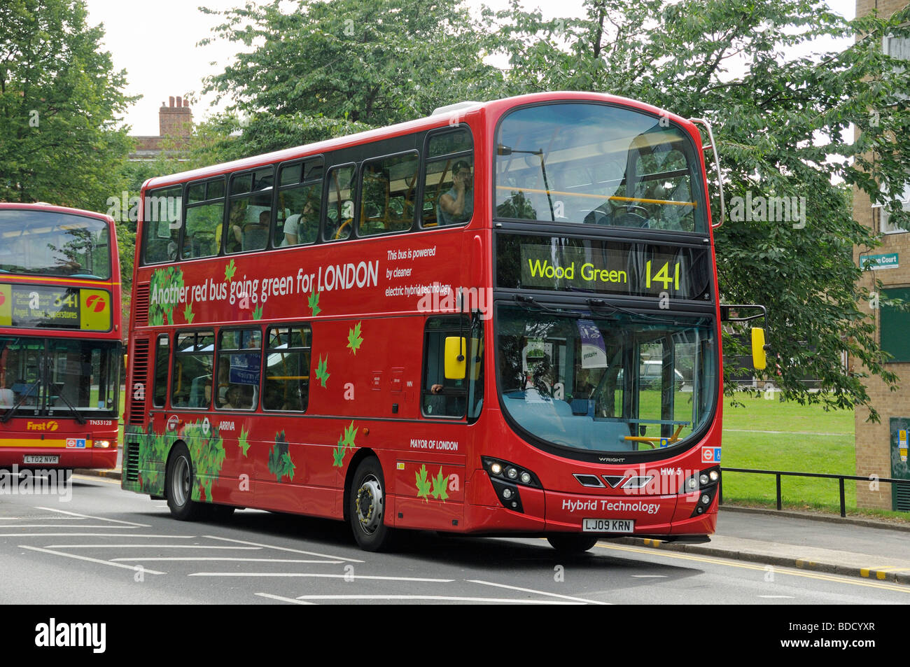 London bus powered by electric hybrid technology with 'Another red bus going green for London' printed on the side England UK Stock Photo
