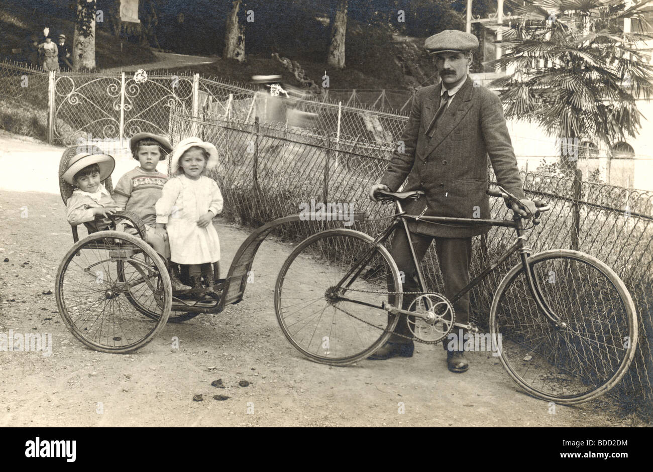 Father Towing Three Kids by Bicycle Stock Photo