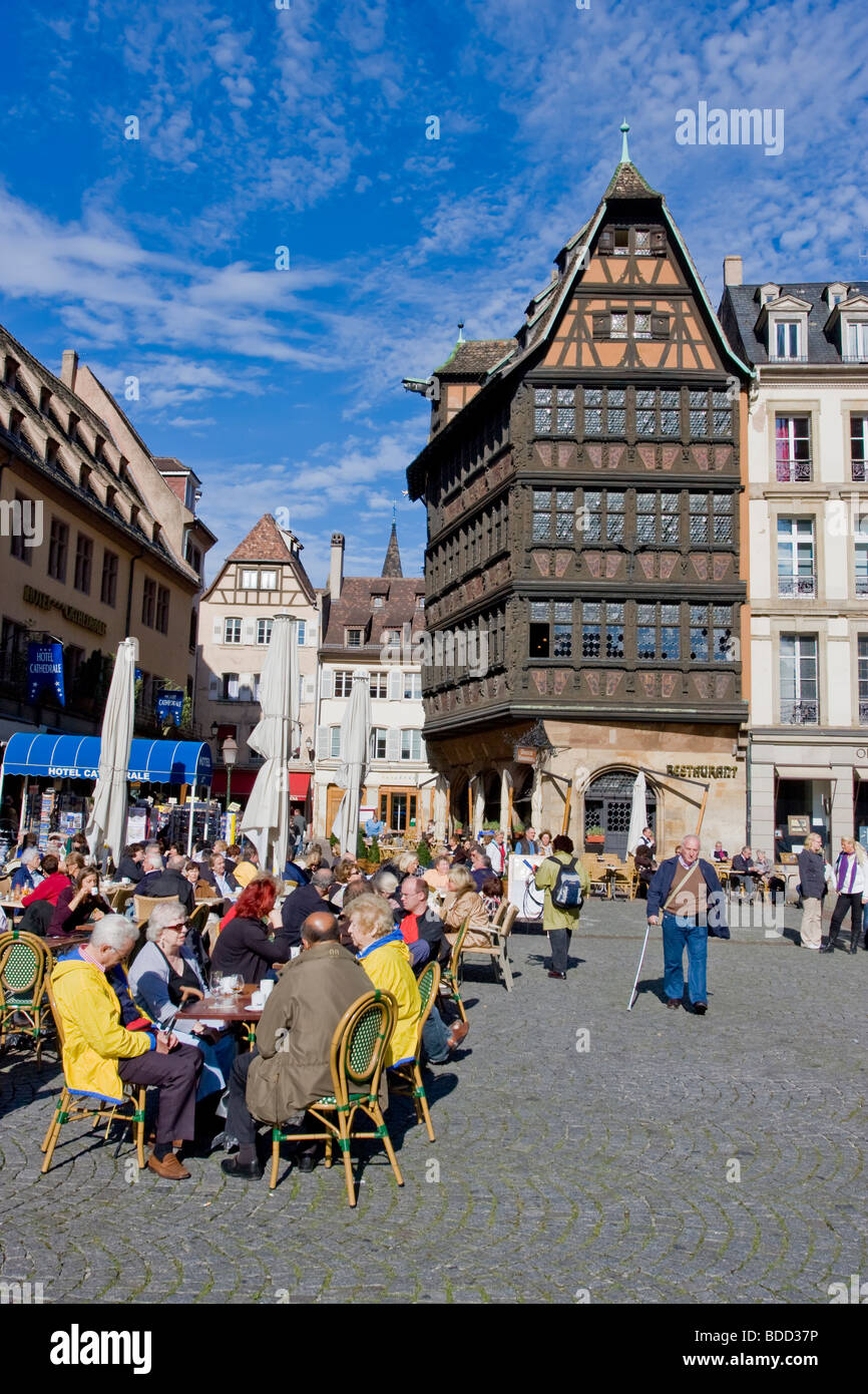 People sitting at cafe terraces on Strasbourg Cathedral square near heritage Kammerzell house, France Stock Photo