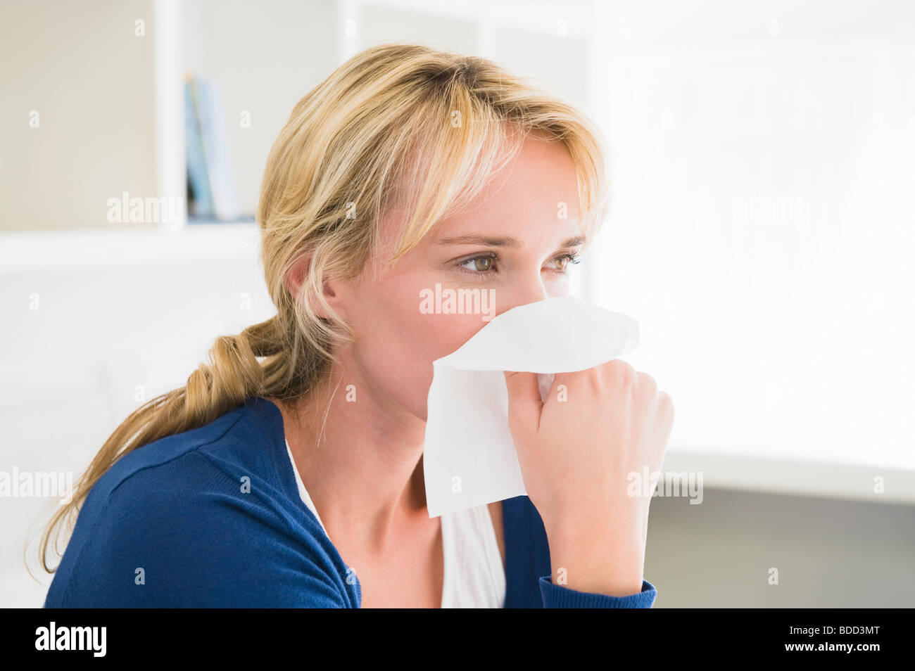 Closeup of a woman blowing her nose with a handkerchief Stock Photo