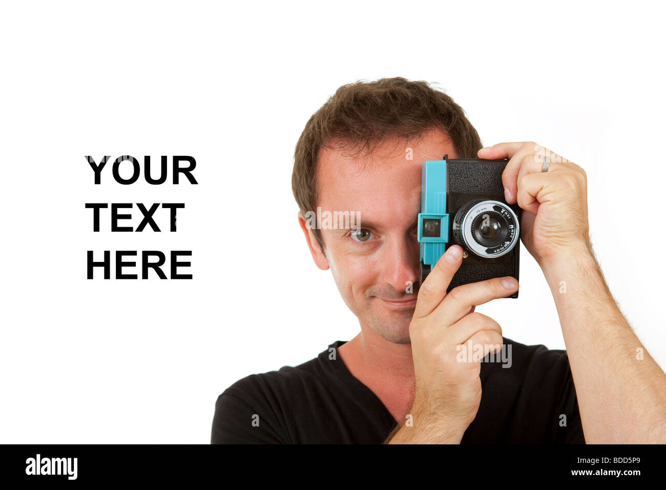 Smiling male photographer with a toy camera on a while background with space for text copy Stock Photo