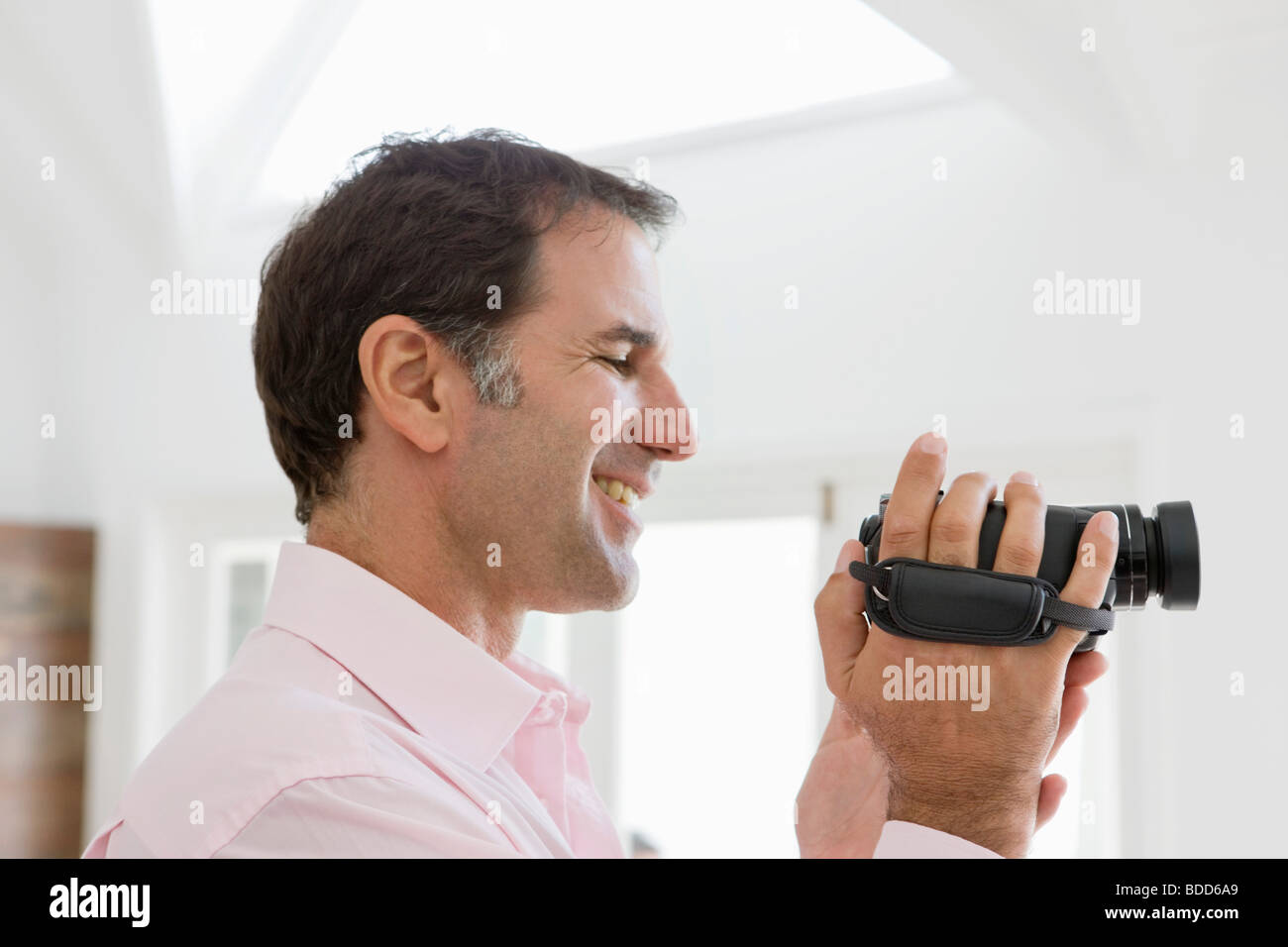 man-holding-a-home-video-camera-and-smiling-BDD6A9.jpg