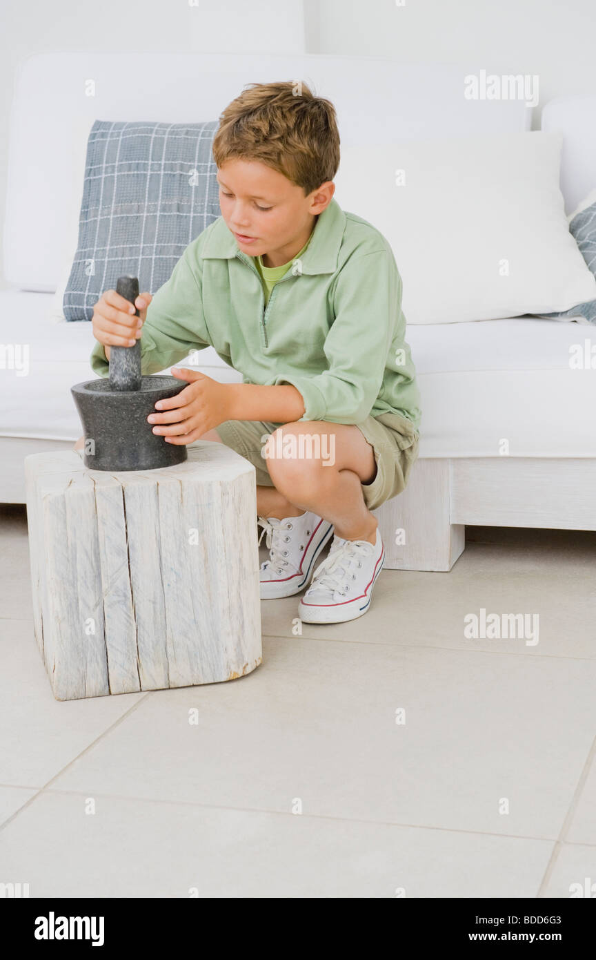 Boy using mortar and pestle Stock Photo
