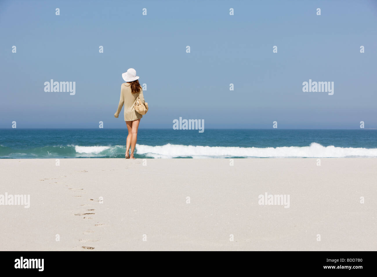 Rear view of a woman standing on the beach Stock Photo - Alamy