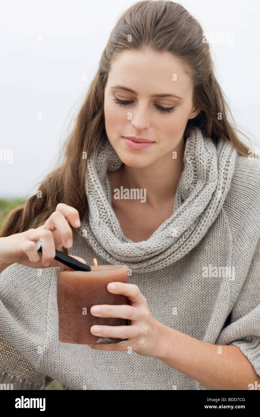 Woman lighting a candle with a cigarette lighter Stock Photo Alamy