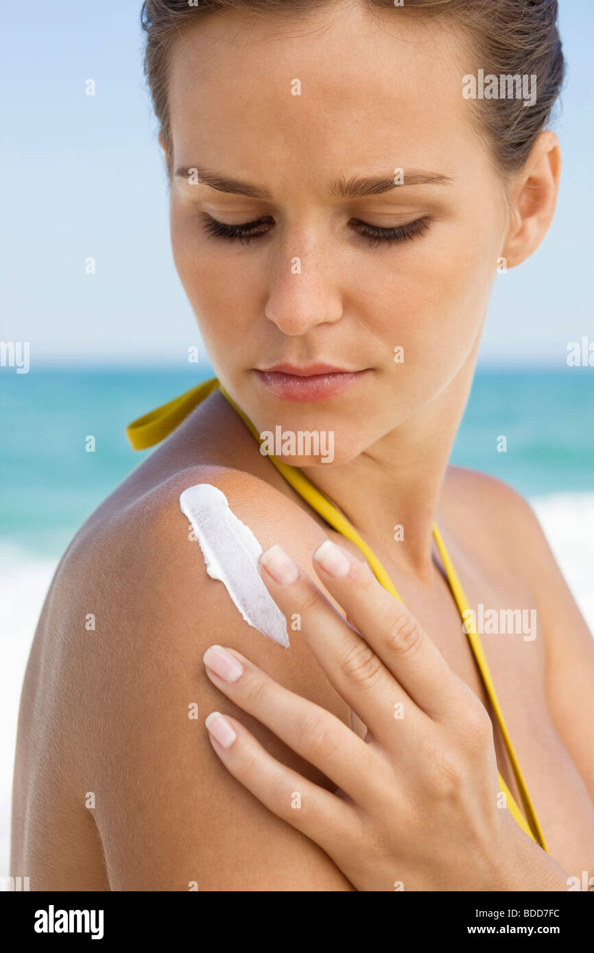 Woman applying suntan lotion on her shoulder Stock Photo Alamy