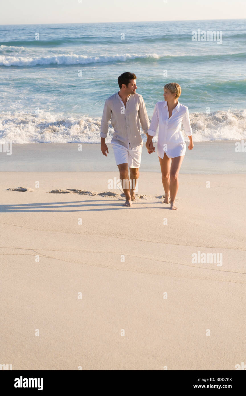 Couple walking on the beach Stock Photo - Alamy