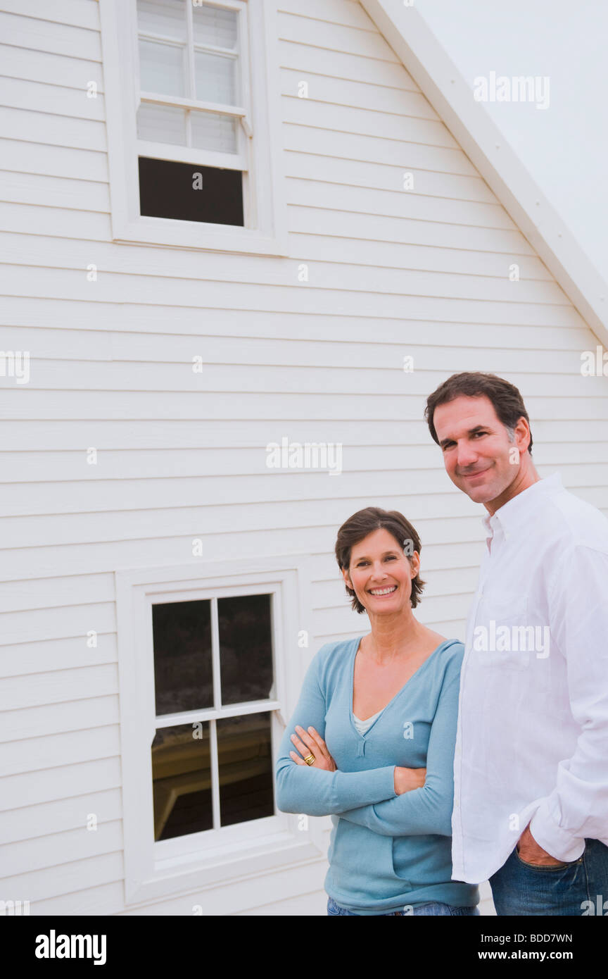 Couple standing together in front of a house Stock Photo - Alamy