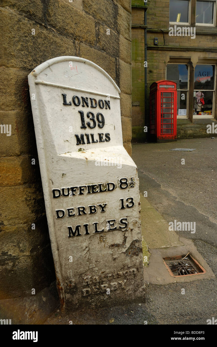Road marker and red telephone box in Wirksworth, derbyshire Stock Photo