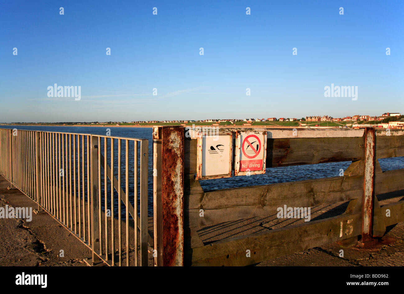 Old warning notices on safety fence at the end of the South Pier at Gorleston, Norfolk, United Kingdom. Stock Photo