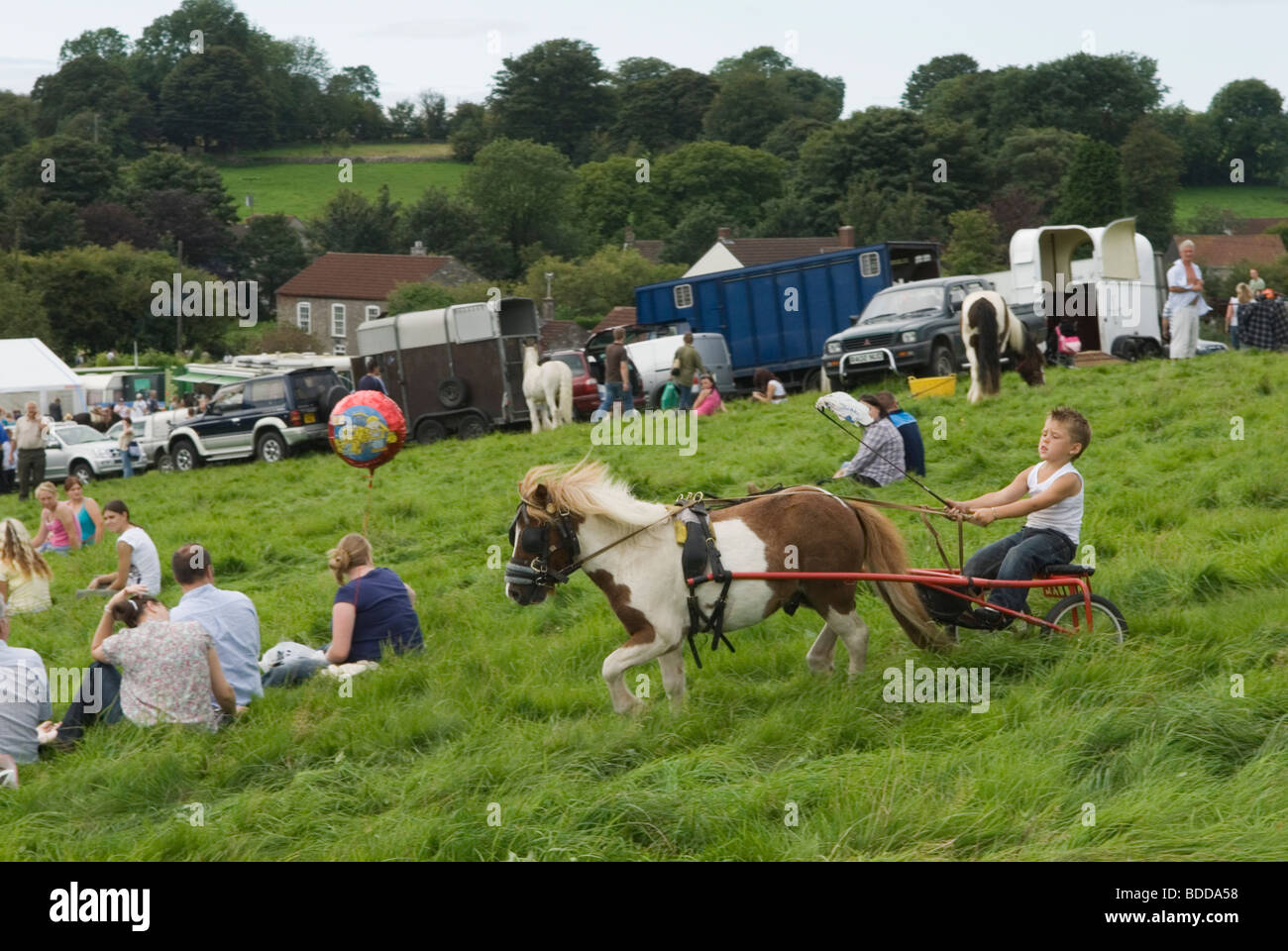 Young boy trotting using a Shetland Pony pulling a horse cart. Priddy Horse Fair Somerset Uk  2000s HOMER SYKES Stock Photo