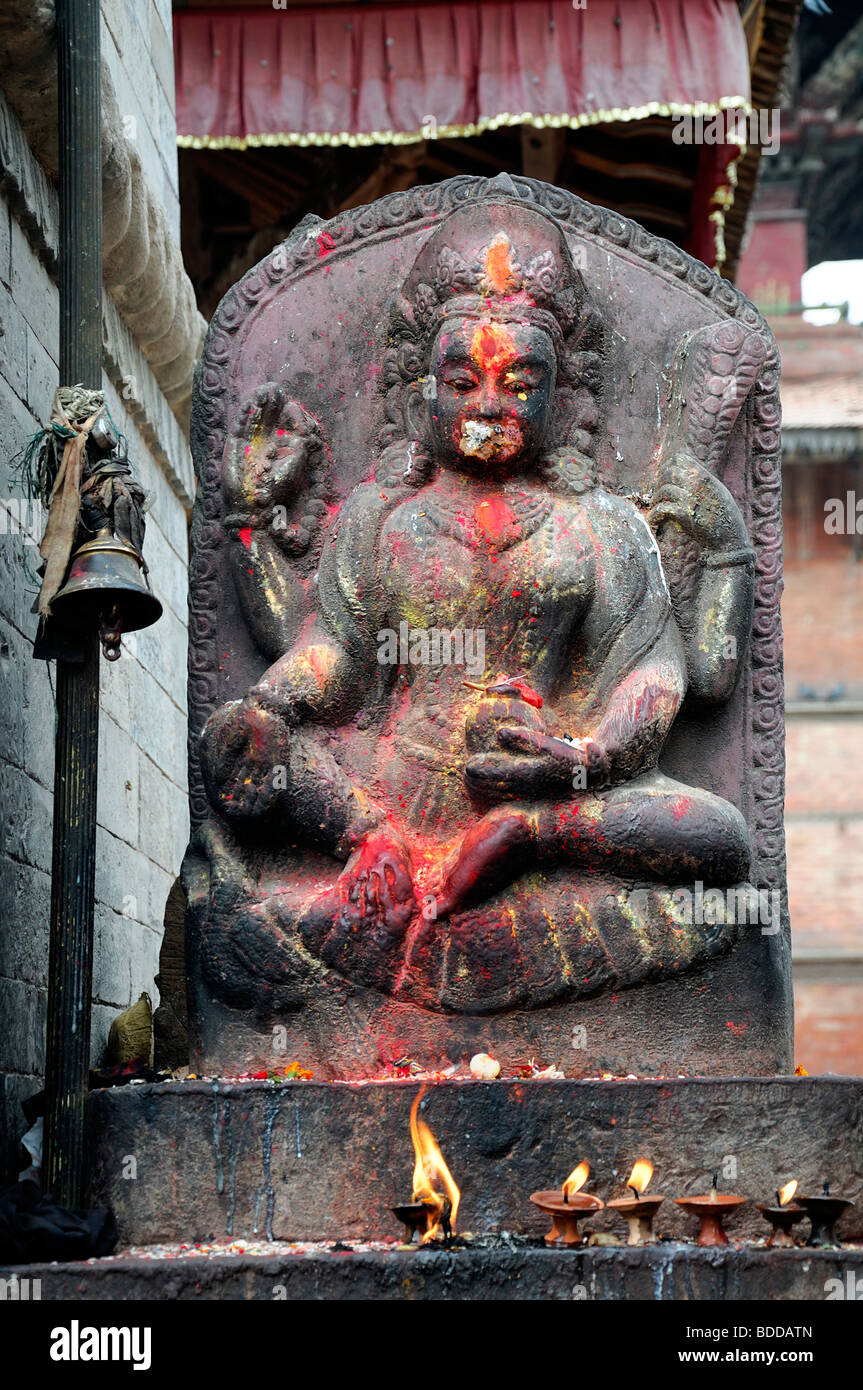 shrine statue of Saraswati buddhist Hindu Goddess of arts and knowledge with votive candles lit lighting durbar square nepal Stock Photo