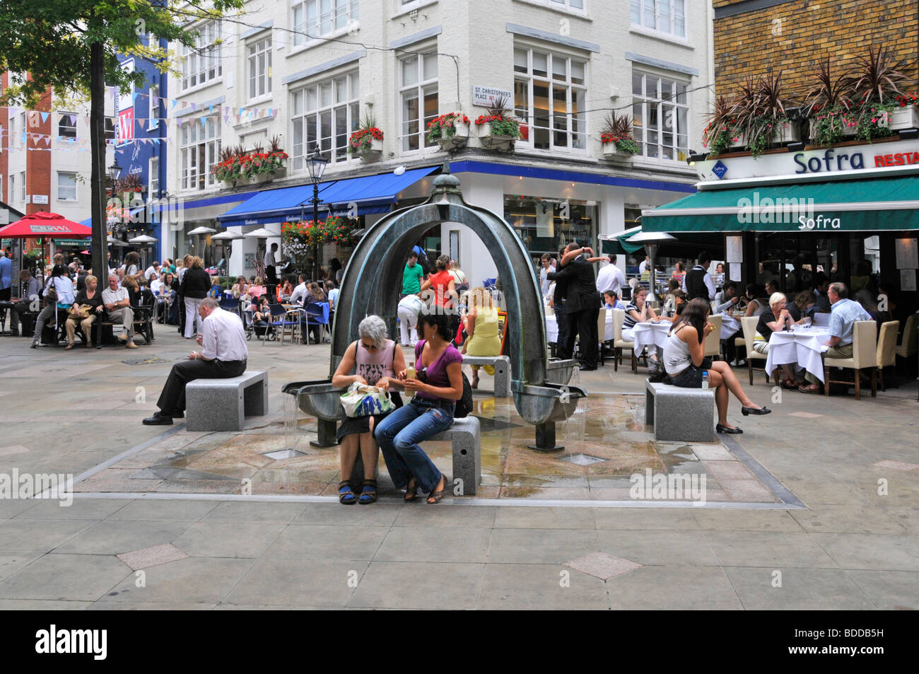 Pavement cafe bars & restaurants in West End London at St Christophers Place just off Oxford Street with water feature fountain Stock Photo