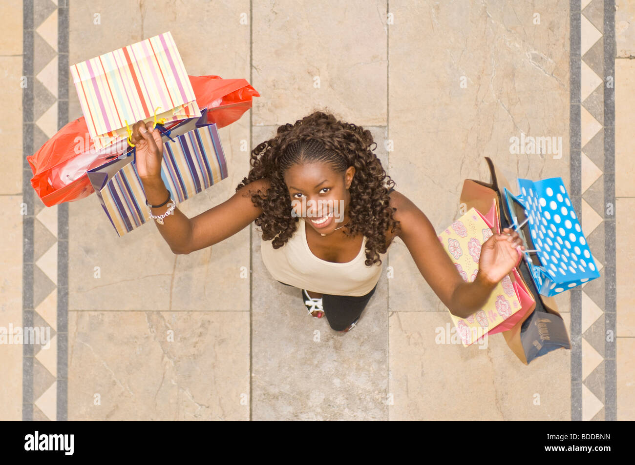 An aerial view of a slim attractive trendy young African woman at a shopping center very happy on a shopping spree. Stock Photo