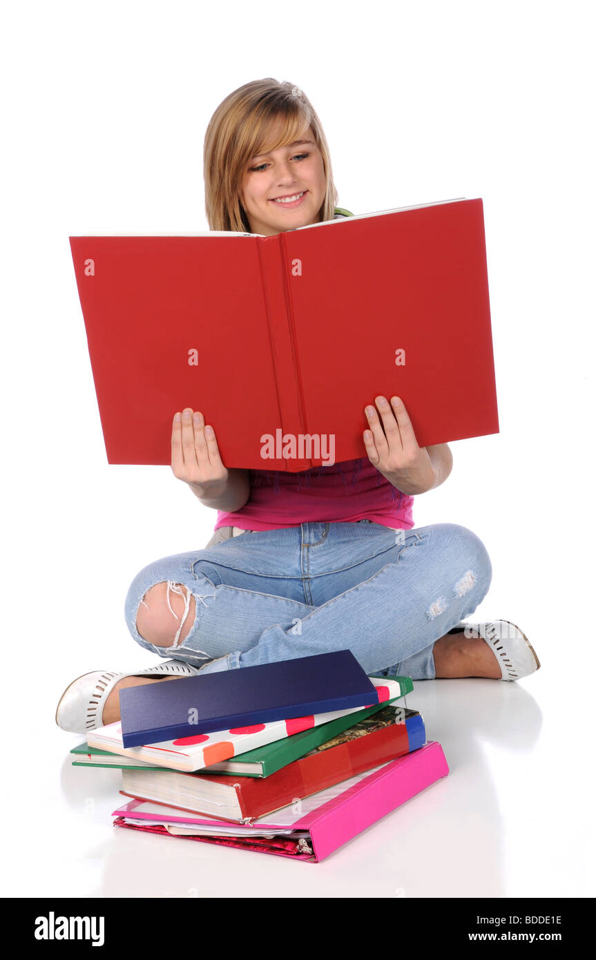 Teen girl reading a book and sitting over a white background Stock ...