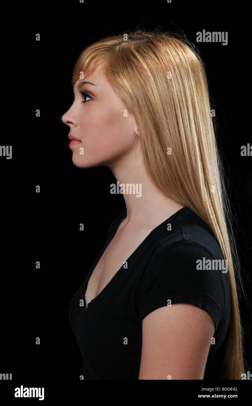 Profile portrait of beautiful teenage girl over a black background ...