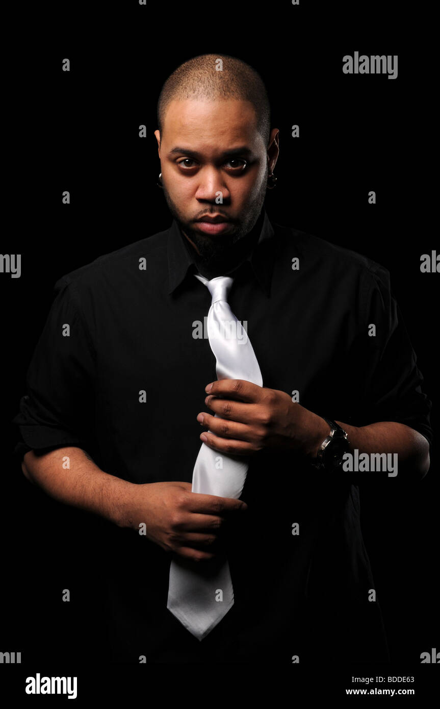 African American man holding tie over a black background Stock Photo