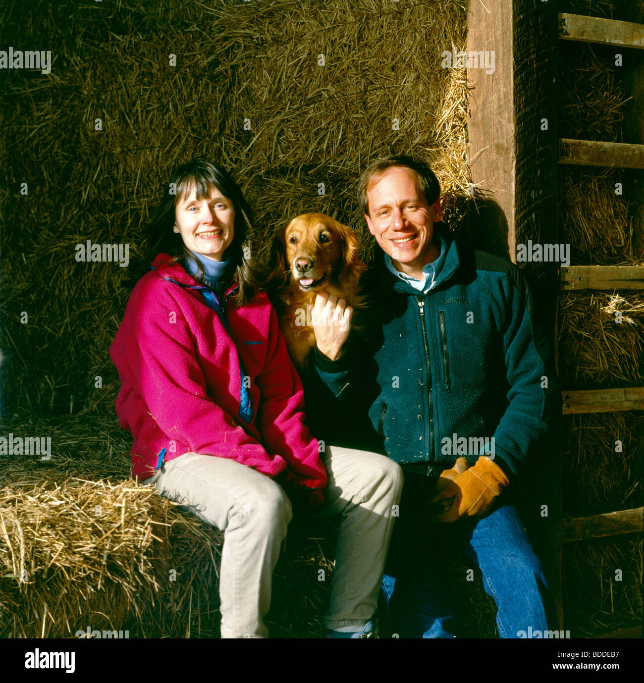 Environmental portrait of photographer H. Mark Weidman and his wife, writer Marjorie A. Ackermann with their Golden Retriever Stock Photo