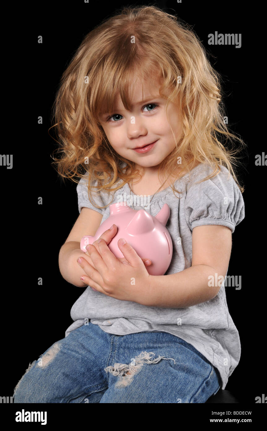 Young girl holding piggy bank isolated over a black background Stock ...