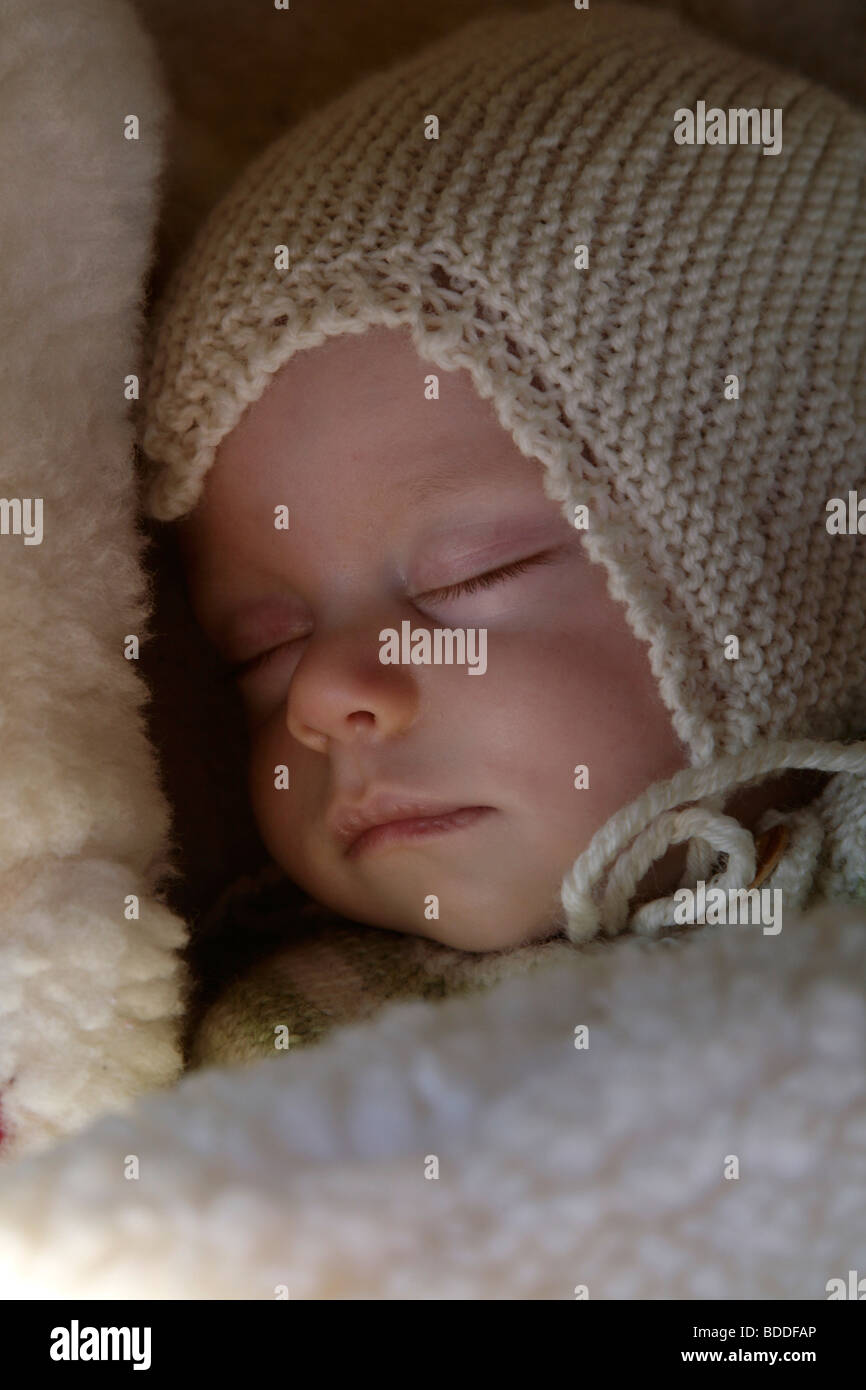 A four month old child wrapped up warm and asleep in a home made