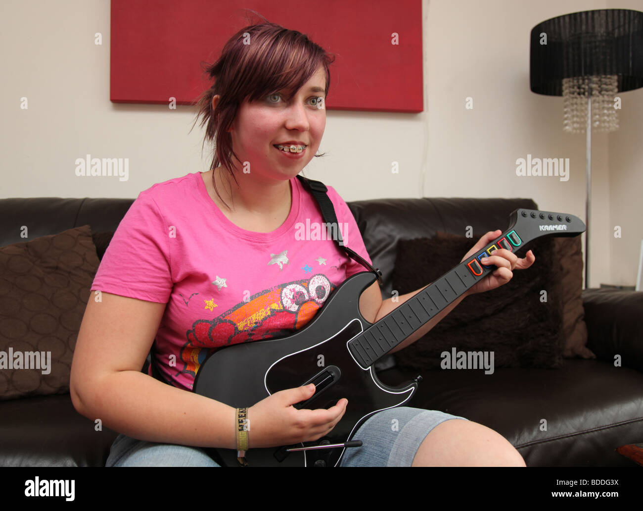 Teenager playing the computer game guitar hero Stock Photo - Alamy