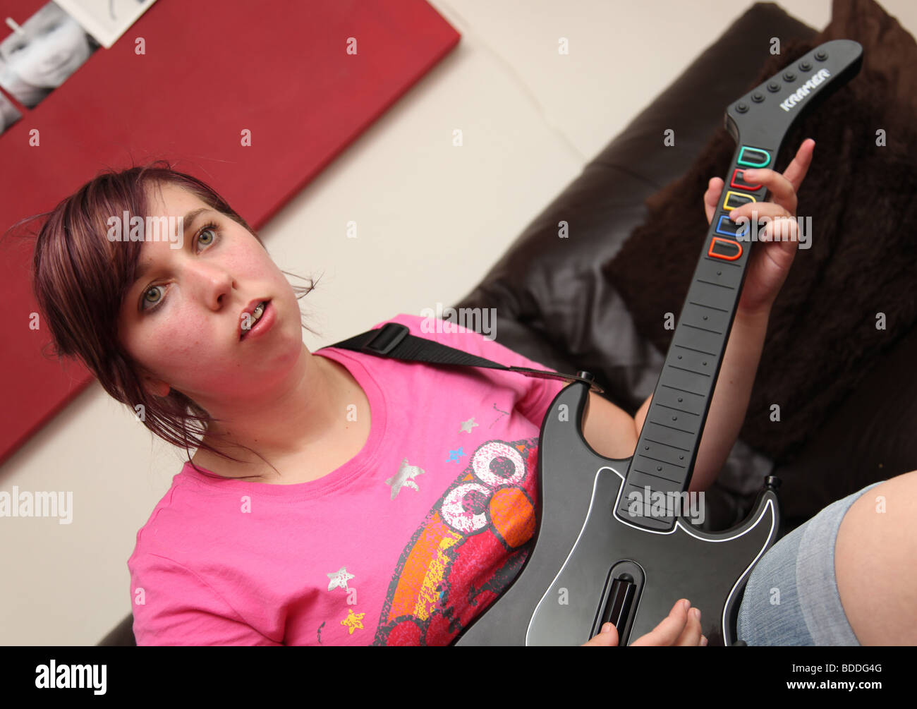 Teenager playing the computer game guitar hero Stock Photo - Alamy