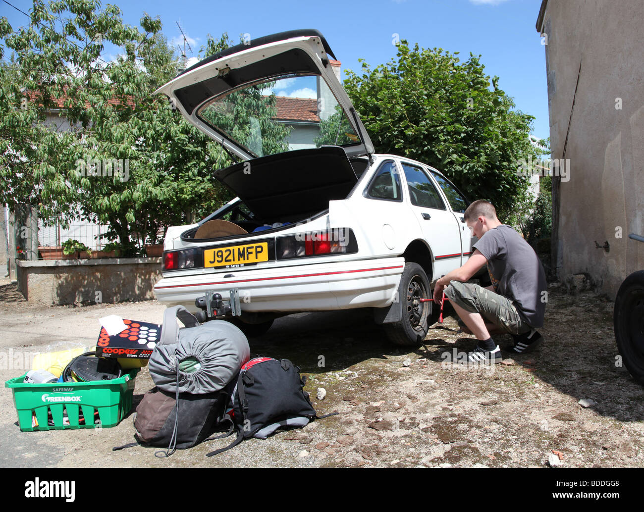 Guy changing punctured tire Stock Photo Alamy
