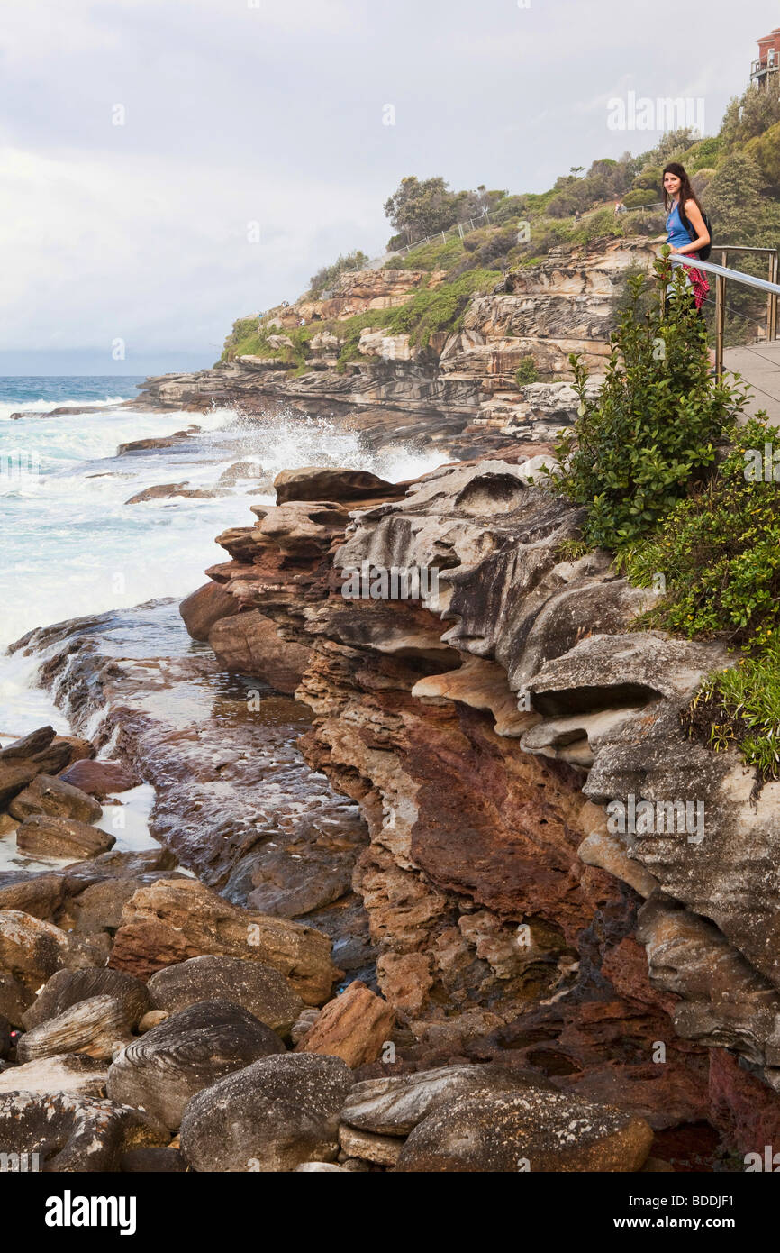 A woman standing on the Sydney coast along the coastal walk from Bondi Beach Stock Photo
