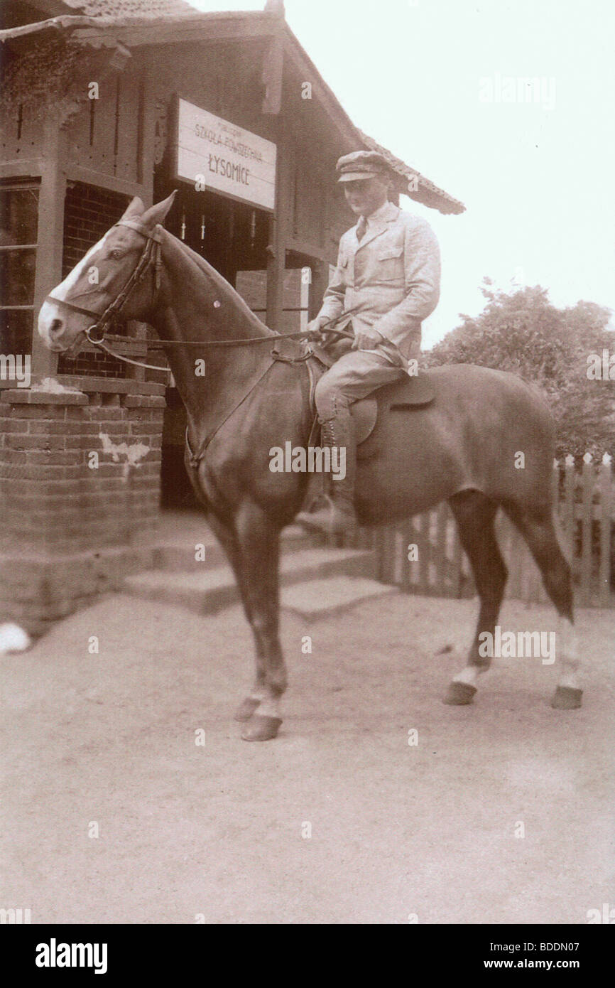 Old photo of a young man on a horse against the background of a country ...